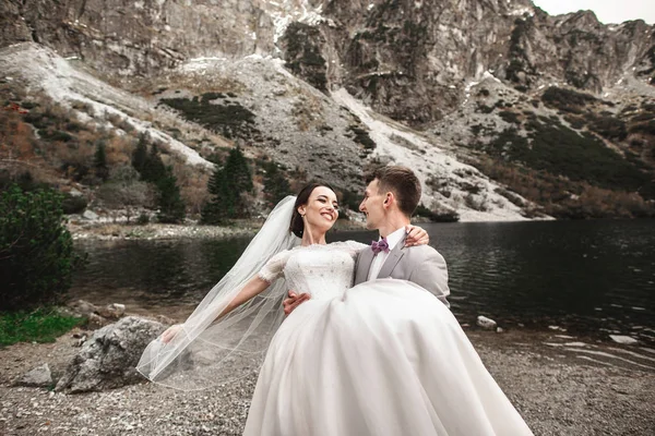 Gyönyörű esküvői photosession. A vőlegény kör fiatal menyasszonya, a parton a tó Morskie Oko. Lengyelország — Stock Fotó