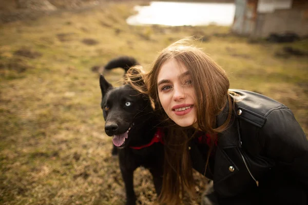 Ein wunderbares Porträt eines Mädchens und ihres Hundes mit bunten Augen. Freunde posieren am Ufer des Sees — Stockfoto
