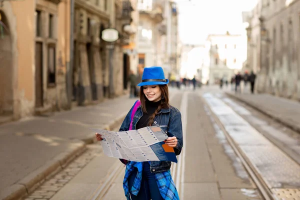 Mulher elegante jovem andando na rua da cidade velha, viajar com mochila e chapéu azul. Ucrânia, Lviv — Fotografia de Stock