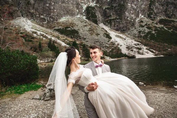 Gyönyörű esküvői photosession. A vőlegény kör fiatal menyasszonya, a parton a tó Morskie Oko. Lengyelország — Stock Fotó