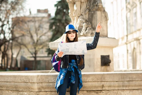 Giovane donna elegante a piedi sulla strada della città vecchia, viaggiare con zaino e cappello blu. Ucraina, Leopoli — Foto Stock