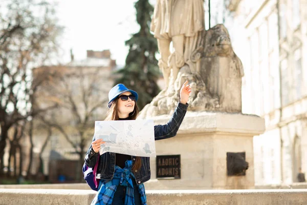 Jonge stijlvolle vrouw wandelen op de oude stad straat, reizen met rugzak en blauwe hoed. Oekraïne, Lviv — Stockfoto