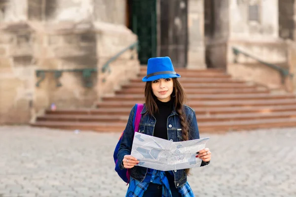 Giovane donna in piedi vicino alla chiesa nella città vecchia Leopoli, e tiene una mappa in mano. Ucraina — Foto Stock