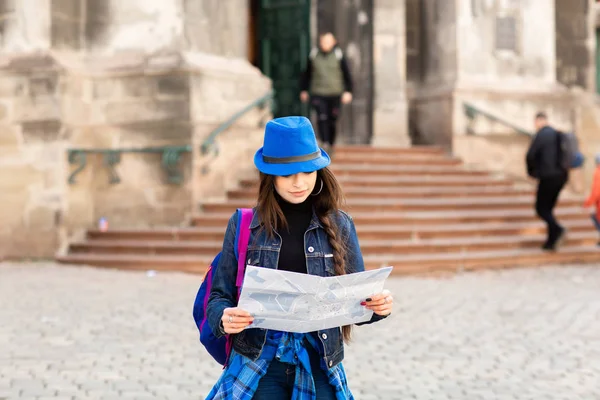 Giovane donna in piedi vicino alla chiesa nella città vecchia Leopoli, e tiene una mappa in mano. Ucraina — Foto Stock