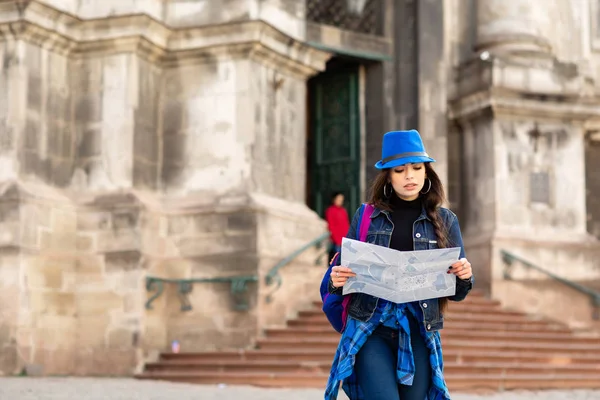 Giovane donna in piedi vicino alla chiesa nella città vecchia Leopoli, e tiene una mappa in mano. Ucraina — Foto Stock