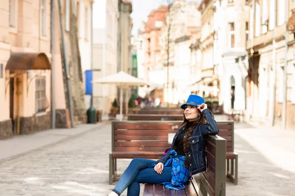 若い女性が古い通りのベンチに座り、休んでいる。リヴィウ, ウクライナ — ストック写真