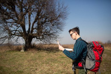 Bir sırt çantası ile bir gezgin, haritaya bakarak ve th yürüme