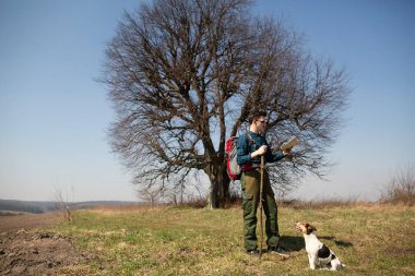 Bir sırt çantası ve köpeği ile bir gezgin, haritaya bakarak ve kırsal yürüyüş
