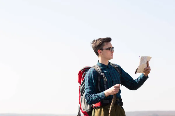 Young Traveler with backpack looking at the map for directions w — Stock Photo, Image