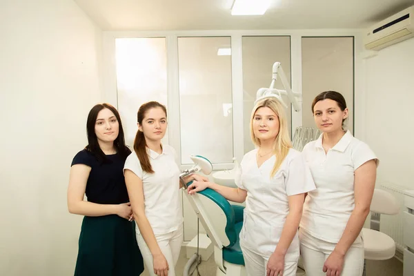 Un equipo de profesionales en una clínica dental, posando cerca del equipo — Foto de Stock