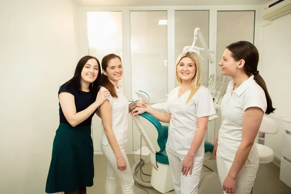 Un team di professionisti in una clinica odontoiatrica, in posa vicino all'attrezzatura — Foto Stock