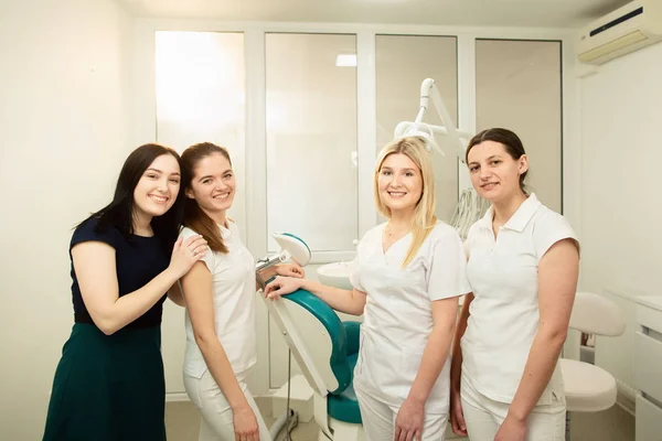 Un team di professionisti in una clinica odontoiatrica, in posa vicino all'attrezzatura — Foto Stock