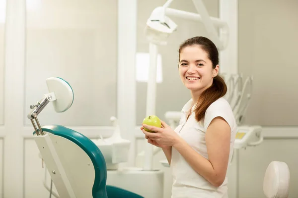 Dentista femminile sorridente e con in mano una mela verde, cura dentale e concetto di prevenzione — Foto Stock