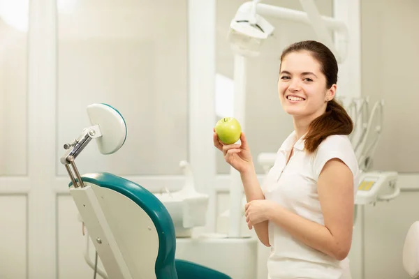 Dentista femminile sorridente e con in mano una mela verde, cura dentale e concetto di prevenzione — Foto Stock