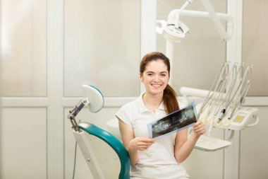Kadın doktor ya da diş hekimi röntgene bakıyor. Sağlık, tıp ve radyoloji kavramı