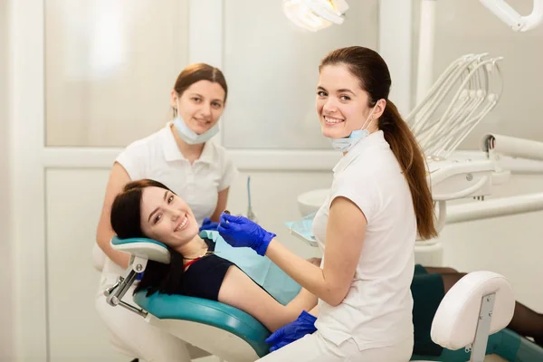 Doctor whit assistant treating teeth of patient, preventing caries. Stomatology concept — Stock Photo, Image