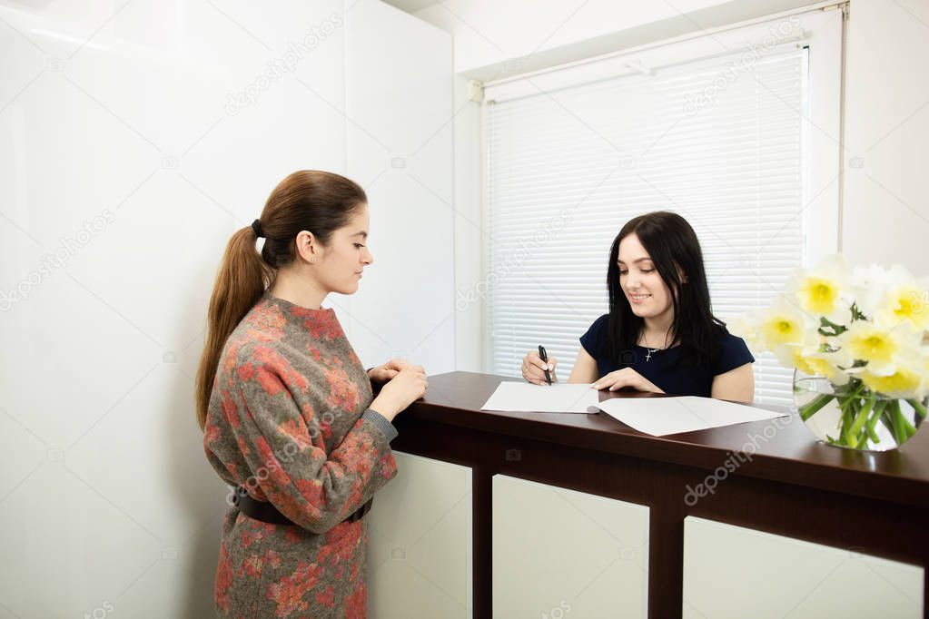 Young woman administrator in a dental clinic in the workplace. Admission of the client