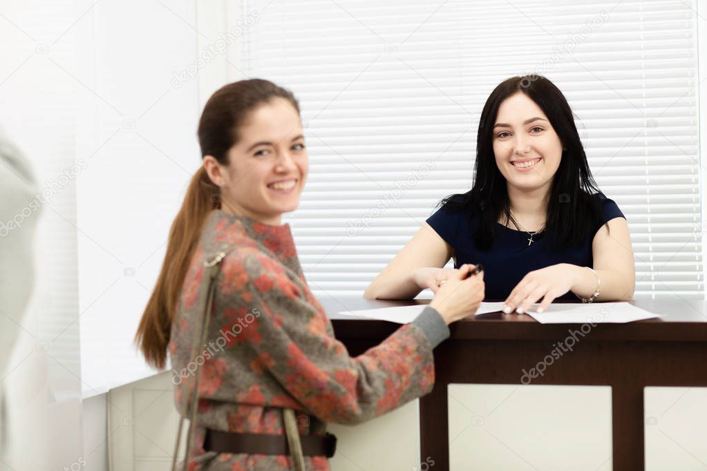 Young woman administrator in a dental clinic in the workplace. Admission of the client