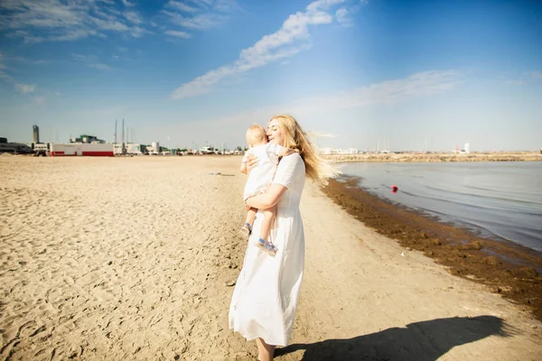 Happy mother huges baby. Mother holds child in her arms, baby hugging mom