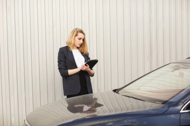 Açık hava kahve molası sırasında, ofis binasının yanında tablet bilgisayar kullanan genç bir iş kadını. İletişim konsepti