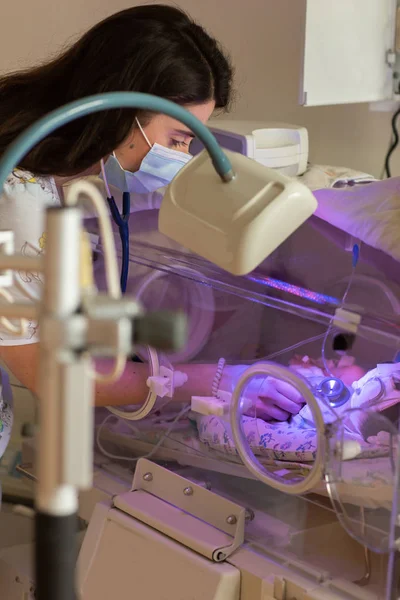 Ženská lékařka vyšetřující novorozence v inkubátoru — Stock fotografie