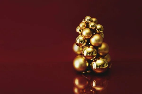 stock image New Year's decoration. Golden balls on a burgundy background with a space for text