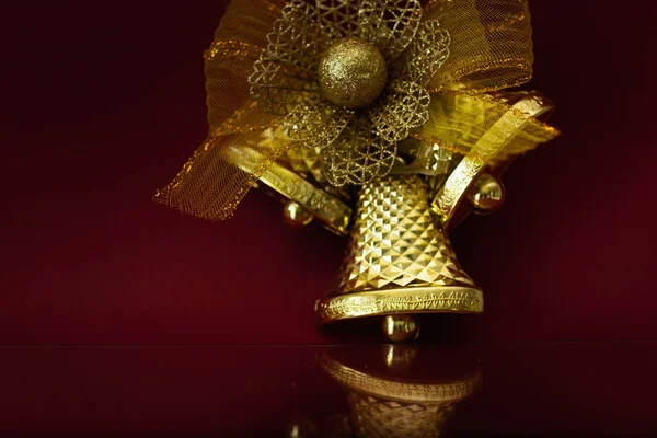 Nieuwjaarsdecoratie. Feestelijke Gouden Bel op een Bourgondische achtergrond met een ruimte voor tekst — Stockfoto