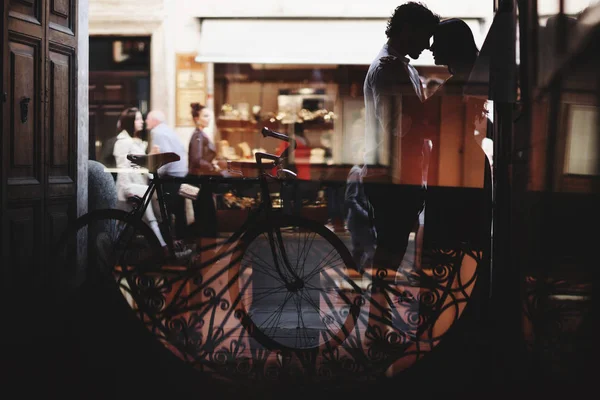 La silueta de una pareja de amor. El hombre y la mujer abrazan suavemente. Caminar con una bicicleta — Foto de Stock