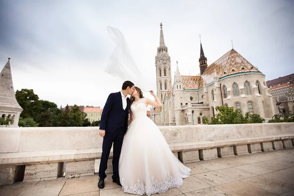 Jonge mooie stijlvolle paar jonggehuwden zoenen door de Fisherman's bastion in Boedapest, Hongarije — Stockfoto