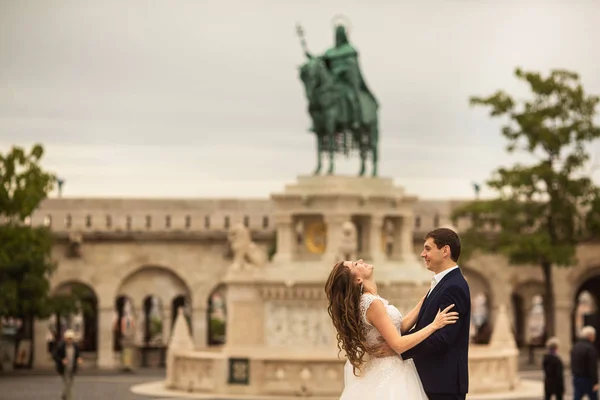 Jonge mooie stijlvolle paar jonggehuwden knuffelen door de Fisherman's bastion in Boedapest, Hongarije — Stockfoto