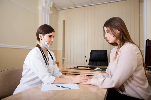 Female doctor holds the patient's hands, reporting the results of the tests. Doctor with patient in a hospital — Stock Photo, Image