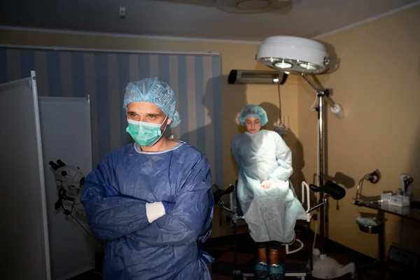 배경에 흥분 한 환자가 있는 차분 한 외과의의 사진 이 있습니다. 수술 준비 로열티 프리 스톡 사진
