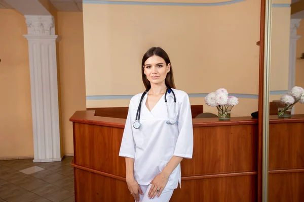 Potret dokter perempuan yang percaya diri mengenakan seragam putih dengan stetoskop di lehernya — Stok Foto