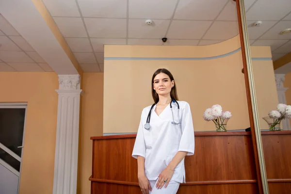 Potret dokter perempuan yang percaya diri mengenakan seragam putih dengan stetoskop di lehernya — Stok Foto