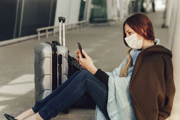 의료용 마스크를 수하물 근처에 비행기를 기다리는 핸드폰을 사용하는 격리되어 비행기를 스톡 사진