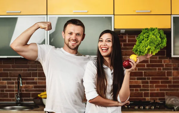 Happy friends menyiapkan makanan untuk makan malam, berpose di dapur sambil memegang sayuran dan buah-buahan. — Stok Foto