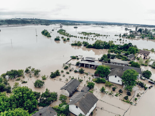Flooded village on Ukraine. Natural disaster in Halych, courtyards and streets in dirty yellow water. Global catastrophe, climate change, flood concept.