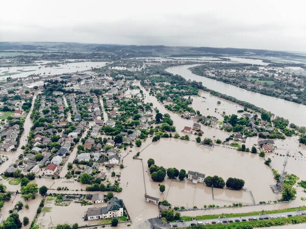 Aerial view of the flooded village of Halych, Prykarpattia, Western Ukraine. The flood on the Dniester River caused a natural disaster. Streets, roads, parks and houses in dirty rainwater.