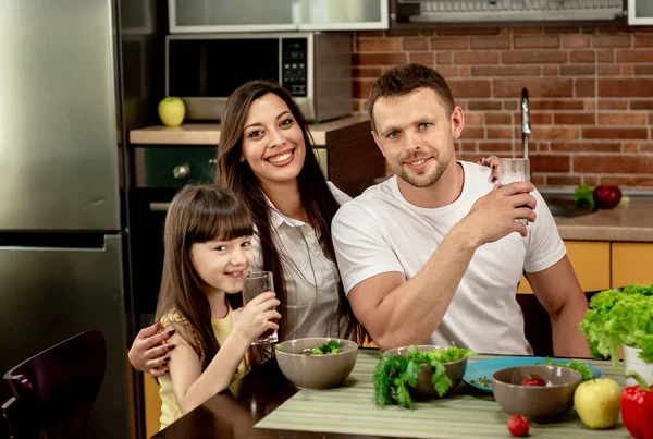 Fröhlicher Vater, Mutter und Tochter frühstücken gemeinsam in der Küche. Gesunde Ernährung, familiäre Beziehungen — Stockfoto