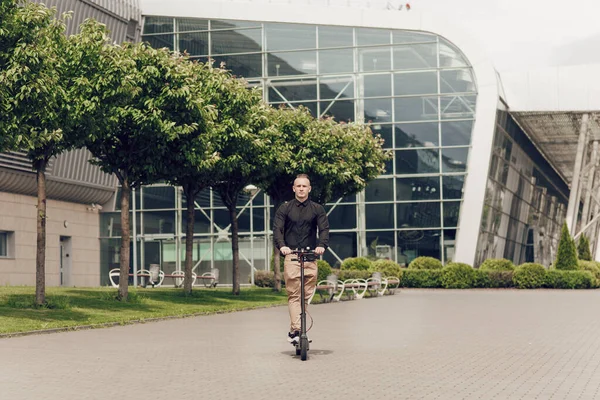 Der junge Mann fährt mit einem Elektroroller durch die Stadt. Das neueste Technologiekonzept, die Entwicklung von Wissenschaft und Technologie — Stockfoto