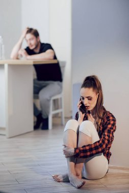 Yüzünde morluklar olan genç ve korkmuş bir kadın kocasından saklanıyor ve polisi arıyor. Mutfakta alkol alan sarhoş bir adam. Aile içi şiddet ve alkolizm kavramı