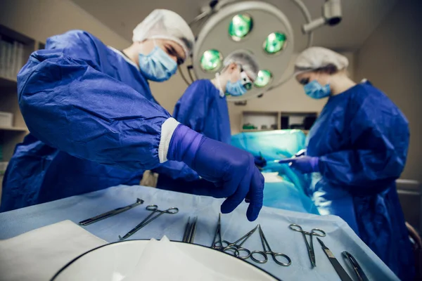 Potret tim ahli bedah di tempat kerja. Tiga dokter bertopeng medis dalam operasi mulai mengoperasi pasien. Dokter dalam pembedahan, pengobatan dan obat-obatan — Stok Foto