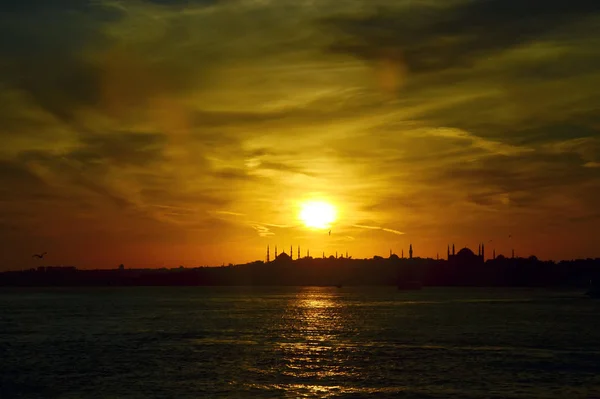 Sunset in Istanbul. Silhouettes  of Sultan Ahmed Mosque (Blue Mosque) and  Hagia Sophia (Ayasofya) Mosque. View from sea of Marmara.  Beautiful colorful sky. Turkey.