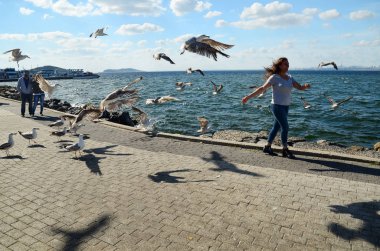 Buyukada ada, Istanbul, Türkiye-10 Mayıs 2018: sahil birçok martılar ile kız. Olumlu duygular. Buyukada gökyüzünde birçok martılar Marmara Denizi üzerinde Prens Adaları biridir.