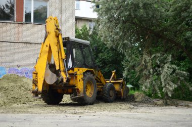 İnşaat alanında taş ocağında büyük bir sarı renkli kazıcı var.