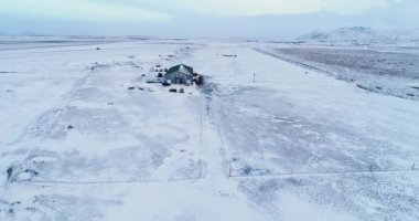 İzlanda 'da karlı tarlalardaki çiftlik evi, hava manzaralı.