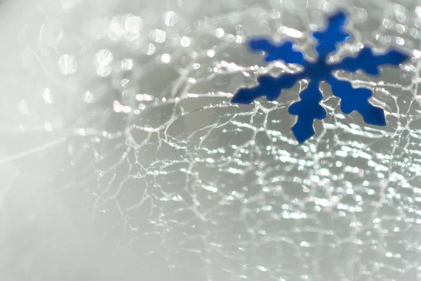 Weihnachten und Neujahr. Schneeflocke vor dem Hintergrund von rissigem Eis — Stockfoto