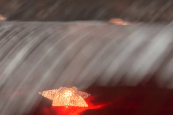 Composición decorativa navideña con una estrella blanca sobre una guirnalda sobre un fondo rojo . —  Fotos de Stock