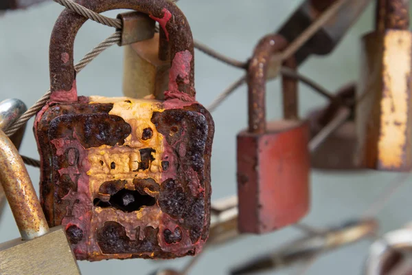 Rusty lovers lock hangs on a metal cable