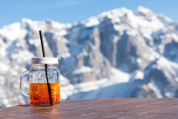 Mok aperol staat op de tafel van een straat café tegen de achtergrond van de bergen. — Stockfoto